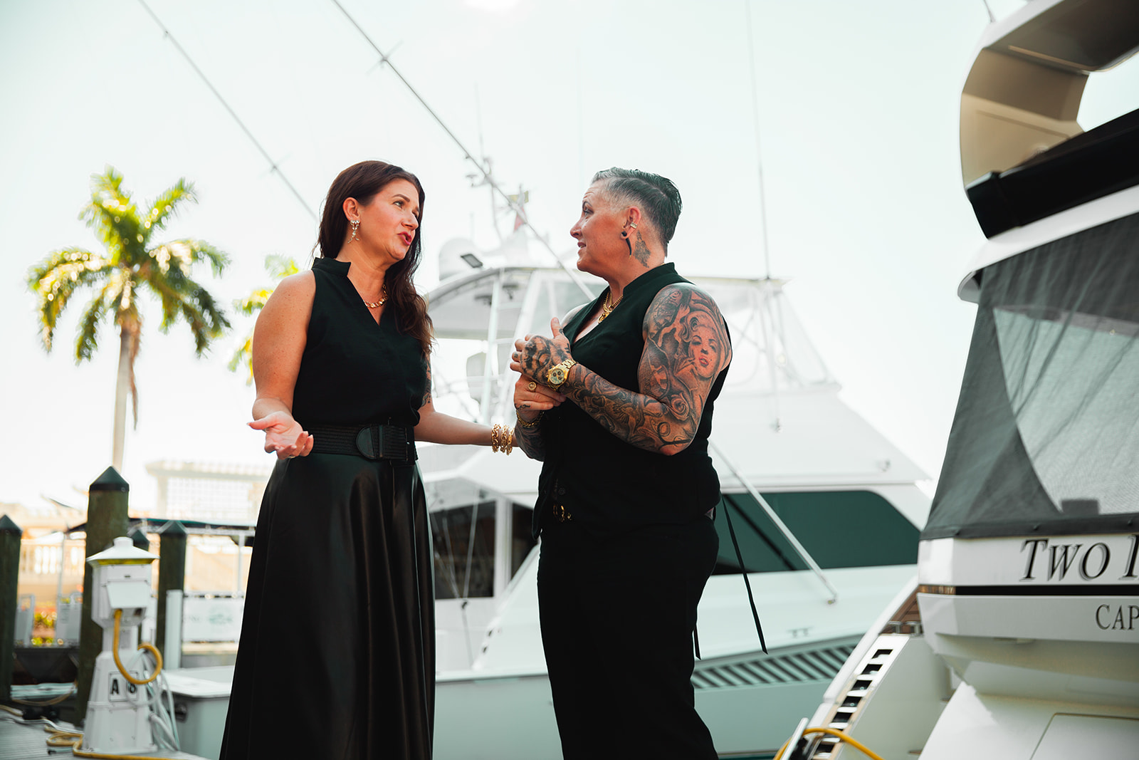 Meredith Banka and Jen Conkey in conversation beside docked yachts